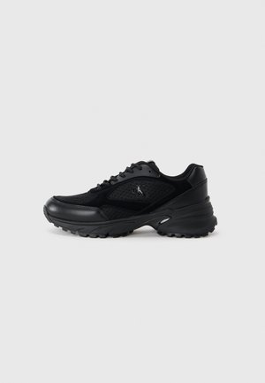 Zwarte sportieve schoenen van gaas en synthetische materialen, gestructureerde oppervlakken, gewatteerde kraag, vetersysteem en een dikke rubberen zool.