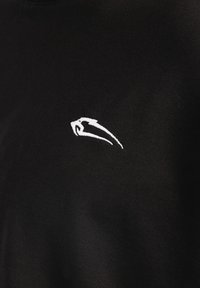 Camiseta negra de manga corta, hecha de tela de algodón suave. Presenta un pequeño logo bordado en blanco en el pecho.