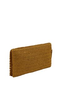 Woven clutch bag w kolorze ciepłego musztardowego. Prostokątny kształt z teksturowanym wzorem szydełkowym i dekoracyjnym brzegiem. Brak widocznych elementów metalowych.