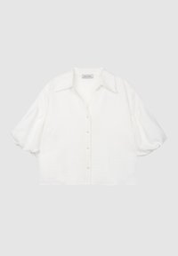 White short-sleeve blouse with a shirt collar, button front, and textured fabric. Features slightly puffy sleeves and pearl buttons.
