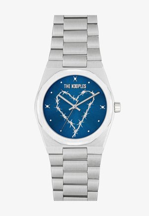 Reloj de acero inoxidable con esfera azul, que presenta un diseño de corazón de alambre de espino, agujas plateadas y marcadores de horas metálicos en una correa de eslabones.