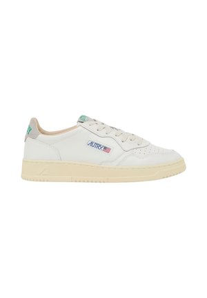 Sneaker bassa bianca con suola beige, lacci e dettagli del logo verde sul lato e sul tallone, mostrata su sfondo bianco.