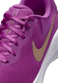 Purple Nike sneaker featuring a textured mesh upper, satin laces, and a gold logo accent on the side, with a white outsole.