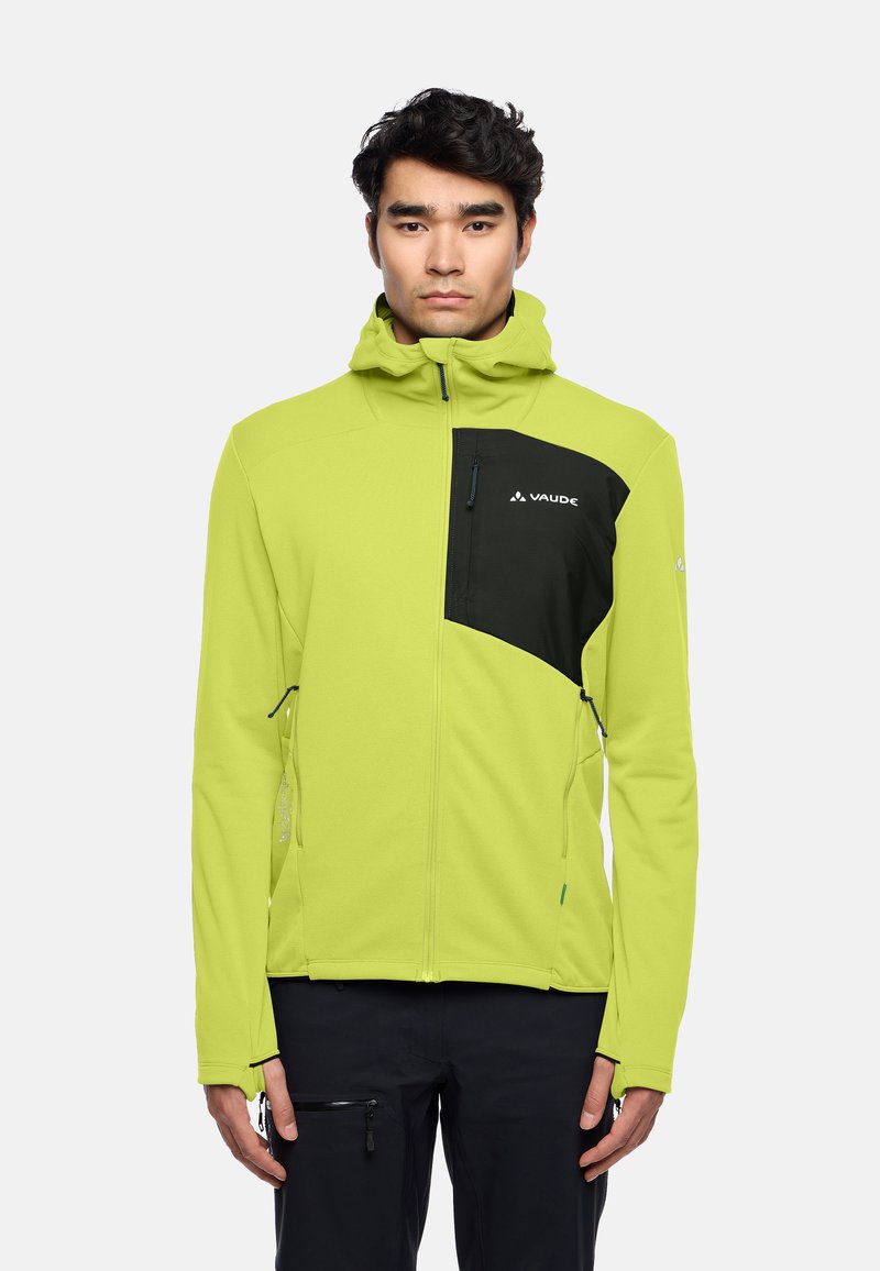 Giacca softshell verde lime con accenti neri sul petto, cappuccio, tasche con zip e dettagli riflettenti. Design leggero e aderente.