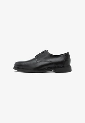 Zwarte leren formele schoen met een gladde afwerking, vetersluiting, ronde neus en lage rubberen zool, met subtiele stiksels.