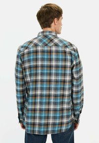 Gestreept flanellen shirt met een mix van blauw, zwart, bruin en wit, met lange mouwen en een button-down kraag.