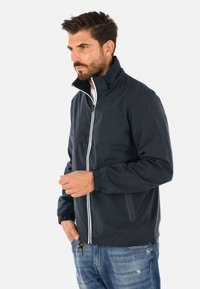 Giacca zip-up blu navy con colletto alto, dettagli in zip bianchi, polsini elasticizzati e tasche laterali. Realizzata in materiale leggero e resistente all'acqua.
