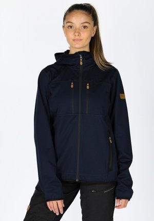 Navy blue softshell jacket with a front zipper, hood, two chest pockets, and contrasting brown zippers and accents. Smooth texture, fitted design.