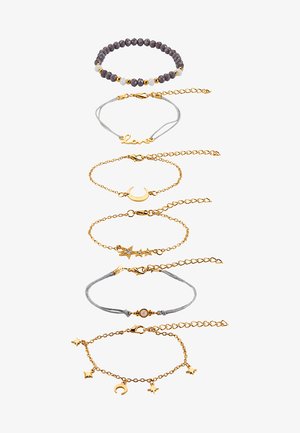 Set di cinque braccialetti in metallo color oro con vari design, tra cui perline, ciondoli e dettagli testurizzati. Include lunghezze sia regolabili che fisse.