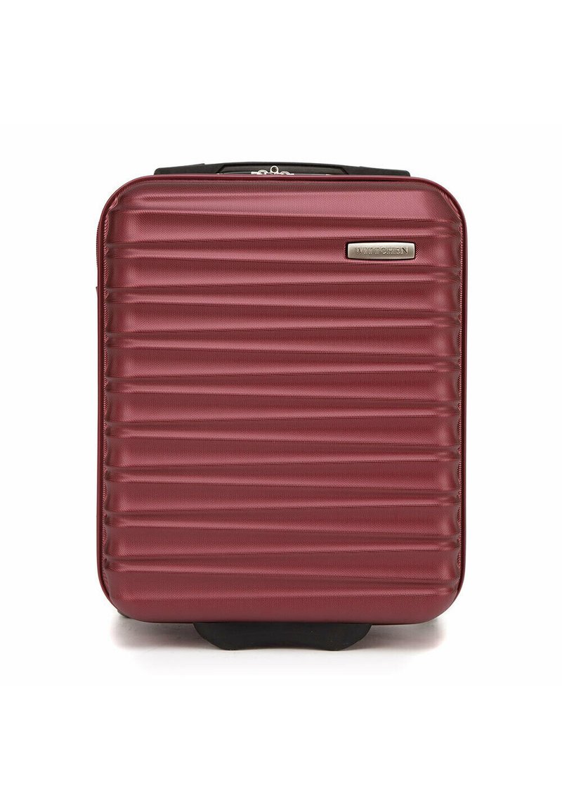 Valigia rigida color bordeaux con texture a righe verticali, una placca logo argentata e una maniglia superiore, progettata per resistenza e comodità durante i viaggi.
