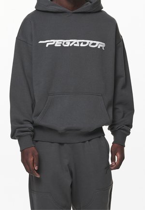 Grå hætte sweatshirt med en frontlomme, ribbede ærmer og bund. Har et hvidt broderet "PEGADOR" logo på brystet.
