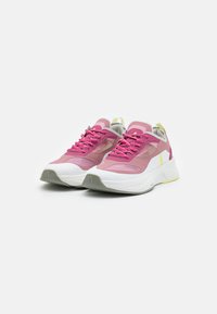 Scarpe sportive rosa e grigie con pannelli in rete, suole bianche spesse e lacci rosa. Presentano un accento giallo sul tallone e una suola texturizzata.