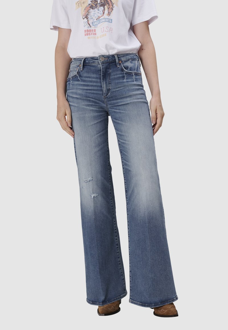 Jeans large bleu clair en denim, avec une taille haute, un léger effet délavé et des détails effilochés à l'avant.