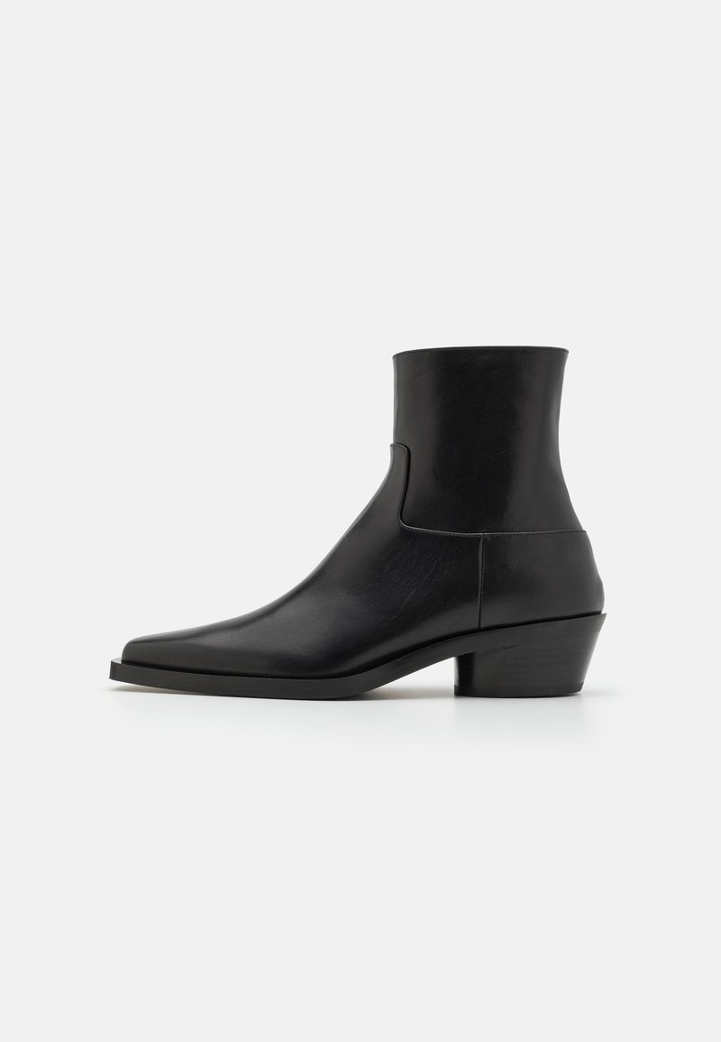 Schwarze Leder-Ankle-Boots mit eckiger Spitze, matter Oberfläche und niedrigem Blockabsatz. Verfügt über ein glattes, stromlinienförmiges Design ohne Verzierungen.