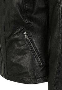 Schwarze Lederjacke mit elegantem Design, strukturiertem Finish und einer schrägen Reißverschlusstasche auf der linken Seite mit silbernem Zubehör.