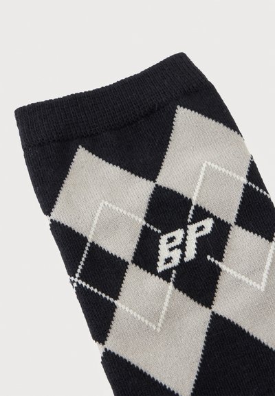 Chaussette argyle noire et grise avec un bord-côte et des lettres blanches brodées "BP" au centre du motif en losange.