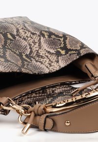 Laukku, jossa on käärmeennahkakuosi beige ja ruskea sävyissä, jossa on sileä sisustus, kultasävyiset yksityiskohdat ja irrotettava hihna.