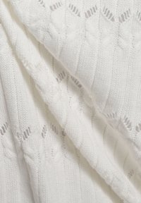 Weißer gestrickter Stoff mit einem gerippten Muster, offener Strickdetail und Zopfstrickakzenten. Weiche Textur mit einem leichten Erscheinungsbild.