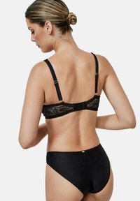 Soutien-gorge en dentelle noire avec bretelles ajustables et accessoires en ton doré, associé à une culotte haute noire. Texture lisse et détail en dentelle florale.