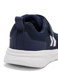 Marineblå mesh atletiksko med en tekstureret overflade, hvid sål og en bageste trækflap. Har et enkelt design med minimale accenter.