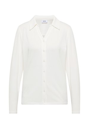 Chemise blanche à manches longues, boutonnée, fabriquée dans un tissu doux, avec un col et une coupe légèrement cintrée. Design simple et polyvalent.