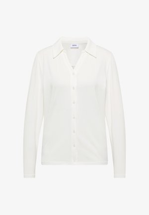 Valkoinen pitkähihainen nappipaidan paita, joka on valmistettu pehmeästä kankaasta. Siinä on kaulus ja hieman kapeneva malli. Yksinkertainen ja monikäyttöinen muotoilu.
