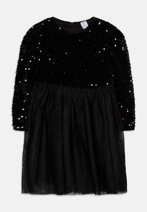 Robe noire à manches longues avec corsage en velours à sequins et jupe en tulle transparent, dotée d'une fermeture éclair dans le dos et d'une taille froncée.