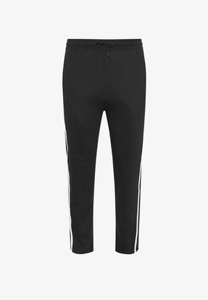 Pantalon de survêtement noir fuselé avec des bandes blanches sur les côtés et une taille à cordon, présenté sur fond blanc.