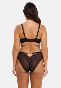 Soutien-gorge en dentelle noire avec dos en dentelle et culottes noires transparentes. Le soutien-gorge a des bretelles réglables et une fermeture à agrafe. Les culottes présentent un détail découpé et des accents en dentelle.