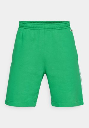 Pantalones cortos de algodón verde con cintura elástica, corte hasta la rodilla, bolsillos laterales y una franja lateral contrastante que presenta acentos de marca.
