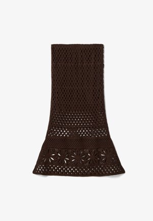 Falda de crochet marrón oscuro con un dobladillo acampanado, que presenta patrones calados de diamantes y flores en toda la tela.