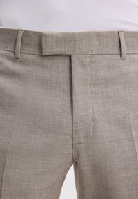 Beige Hosen aus strukturiertem Stoff, mit geradem Schnitt und vorderen Falten sowie einem flachen Bund, entworfen für eine maßgeschneiderte Passform.