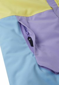 Kolorowa kurtka wiatrówka z żółtymi, fioletowymi i niebieskimi panelami; posiada boczną kieszeń na suwak oraz gładką, lekką fakturę tkaniny.
