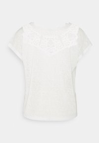 Top corto de manga corta blanco con borde de encaje alrededor del escote, textura suave, diseño holgado y ajuste relajado.