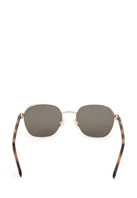 Gafas de sol de marco metálico con lentes oscuros octagonales. Los laterales presentan un patrón de carey. Almohadillas nasales transparentes para mayor comodidad y ajuste.