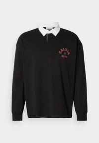 Μαύρο πόλο μπλουζάκι με μακριά μανίκια και λευκό γιακά, που διαθέτει ένα μικρό κόκκινο εκτυπωμένο λογότυπο στο στήθος και κλασικό κλείσιμο με κουμπιά.