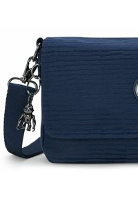Borsa a tracolla navy con tessuto testurizzato, chiusura a pattina, hardware in argento e un charm nero decorativo attaccato alla tracolla.