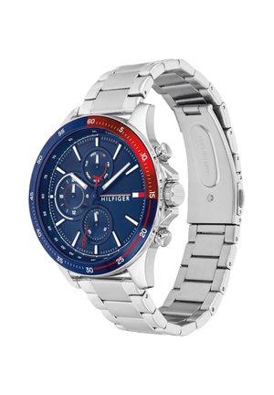 Hõbedase metallrihmaga käekell sinise ja punase raami, sinise sihverplaadi, kolme väikese sihverplaadi, valgete indeksite ja "Hilfiger" logoga kellaplaadi peal.