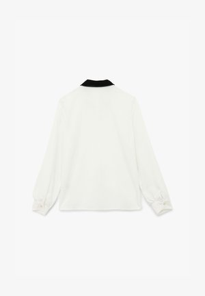 Blusa blanca de manga larga, con cuello negro, puños abotonados y una textura suave, que presenta una silueta recta y sin patrones visibles.