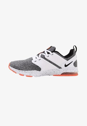 Baskets Nike grises et blanches avec lacets blancs, semelle blanche tachetée, accents orange et logo Nike noir sur le côté.