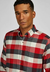 Rode, zwarte en witte geruite flanellen overhemd met een button-down kraag en borstzak. Gelaagd materiaal met zichtbare stiksels en knopen.