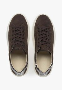 Braune Wildledersneaker mit dunklen Schnürsenkeln, einer weißen Gummisohle und einem strukturierten Stoffakzent an der Ferse. Das Innere ist hellbeige.