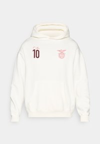 Sudadera blanca con capucha, texto rojo "O Rei", número 10 en el pecho izquierdo y un logotipo de águila roja en el pecho derecho, con bolsillo canguro en la parte delantera.