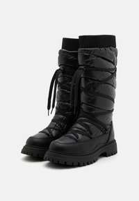Botas acolchadas negras con punta redonda, acabado texturizado, suela de goma y cordones en la parte delantera. La parte superior presenta un detalle acolchado y un puño de tejido.