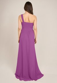 Ärmelloses, bodenlanges Kleid in leuchtendem Lila. Es verfügt über ein gerafftes Oberteil und fließenden Stoff für ein luftiges Erscheinungsbild.