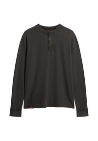 Camisa henley de manga larga en gris oscuro, con cinco botones de madera en el cuello, textura acanalada y un dobladillo ligeramente redondeado con una etiqueta.