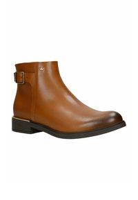 Braune Lederstiefelette mit seitlichem Schnallenverschluss, niedrigem Blockabsatz und metallischem Logodetail am oberen Rand.