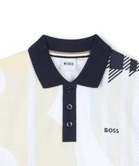 Poloshirt met een witte basis, voorzien van geometrische patronen in geel en marineblauw. Marineblauwe kraag met drie zwarte knopen en logo-detail.