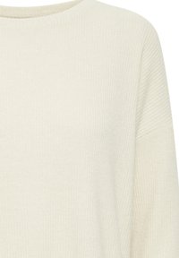 Pullover a coste di un beige chiaro con scollatura rotonda e spalle scese. Il tessuto ha una consistenza morbida e un sottile motivo verticale.