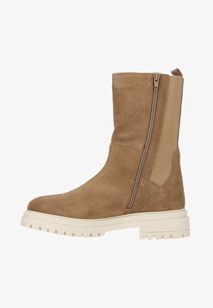 Tan suede ankle boot with a textured finish, elastic side panel, and a functional zipper; features a solid white chunky sole.
